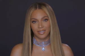 Beyoncé smiling at the camera, wearing a choker necklace