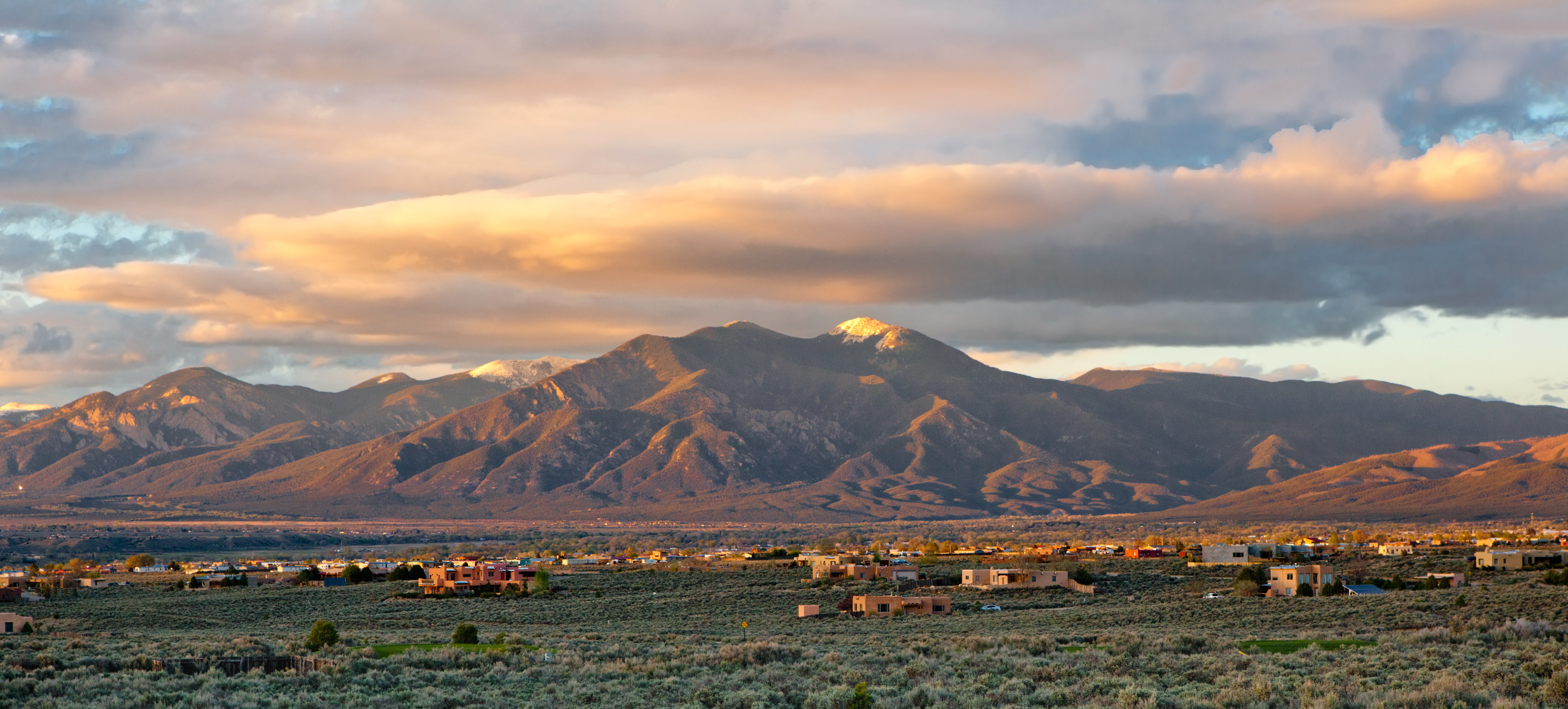 Mountain landscape at sunset with foreground of small town buildings