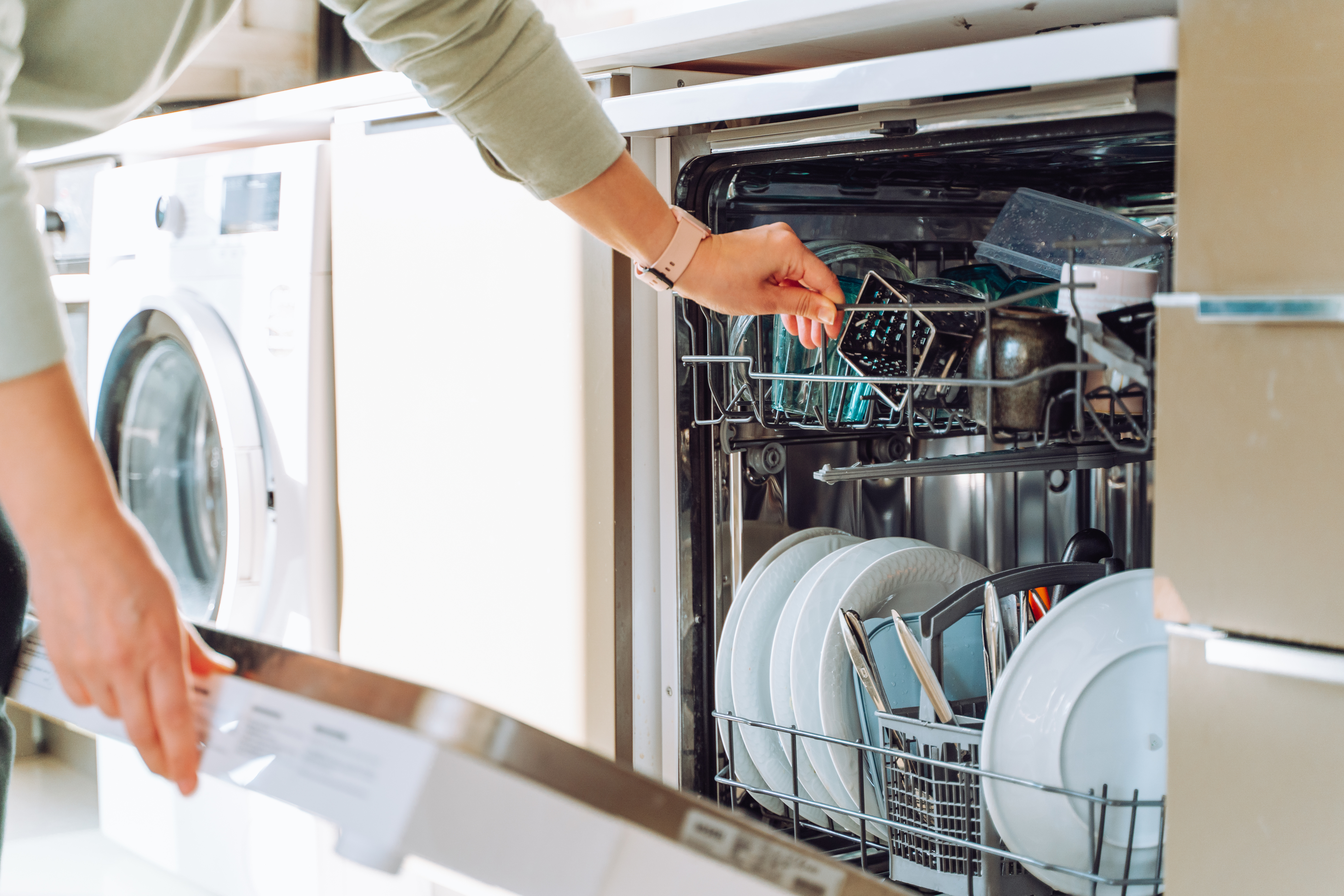 person emptying a dishwasher