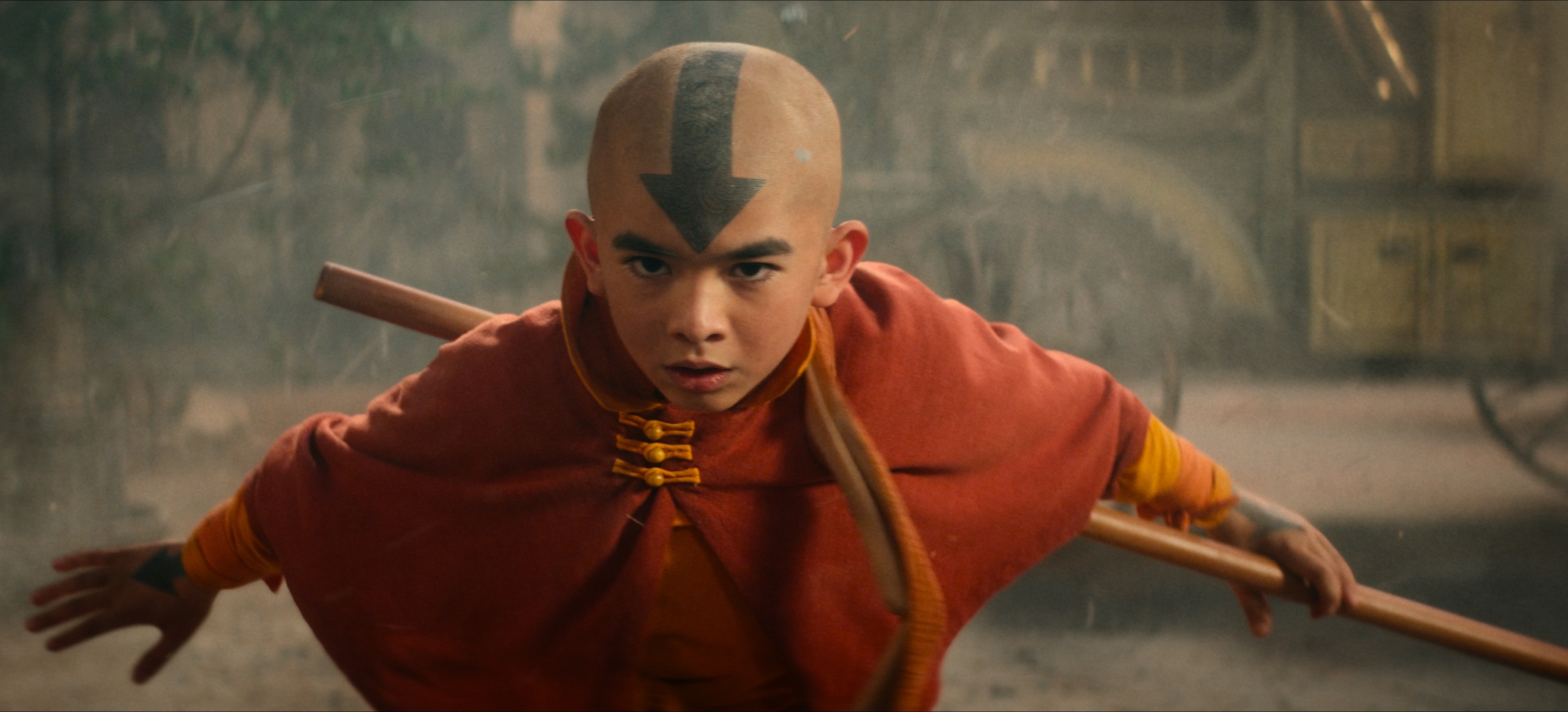 Aang from Avatar: The Last Airbender in action pose, holding a staff, dressed in traditional Air Nomad attire