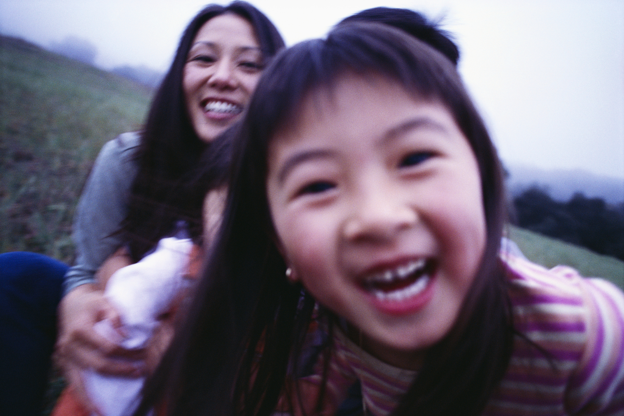 Woman and child smiling, close-up, out of focus, giving an impression of joy and movement