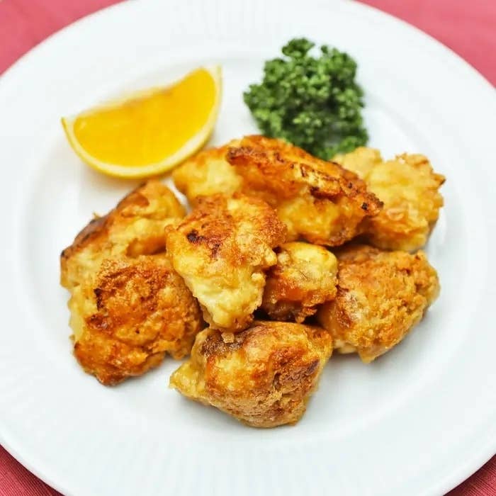皿に盛られた豆腐の唐揚げ、添えられたレモンとパセリ。