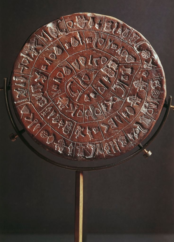 Ancient disc with inscribed text on a stand, possibly used for ceremonial or informational purposes