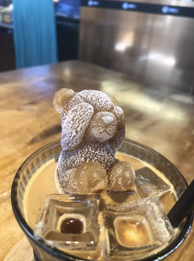 Gummy bears arranged atop a cold coffee, creating a whimsical bear sculpture
