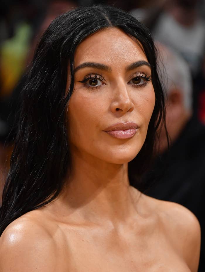 Kim Kardashian wearing a strapless black top, with straight long hair, looking forward