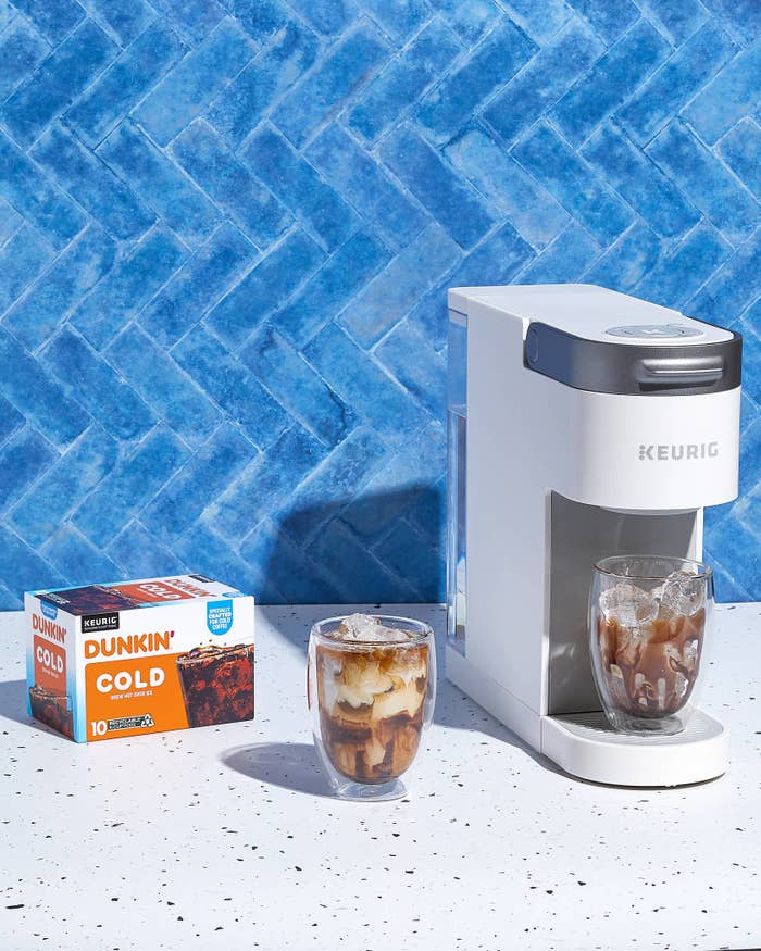 Keurig machine with Dunkin&#x27; Cold coffee pods and a glass of iced coffee