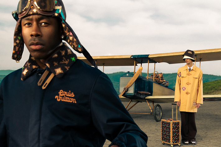 Two models pose with Louis Vuitton attire and accessories, one standing by a vintage plane
