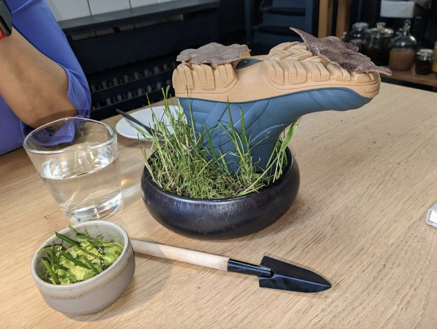 a hiking boot in a bowl of grass being used as a tray for food