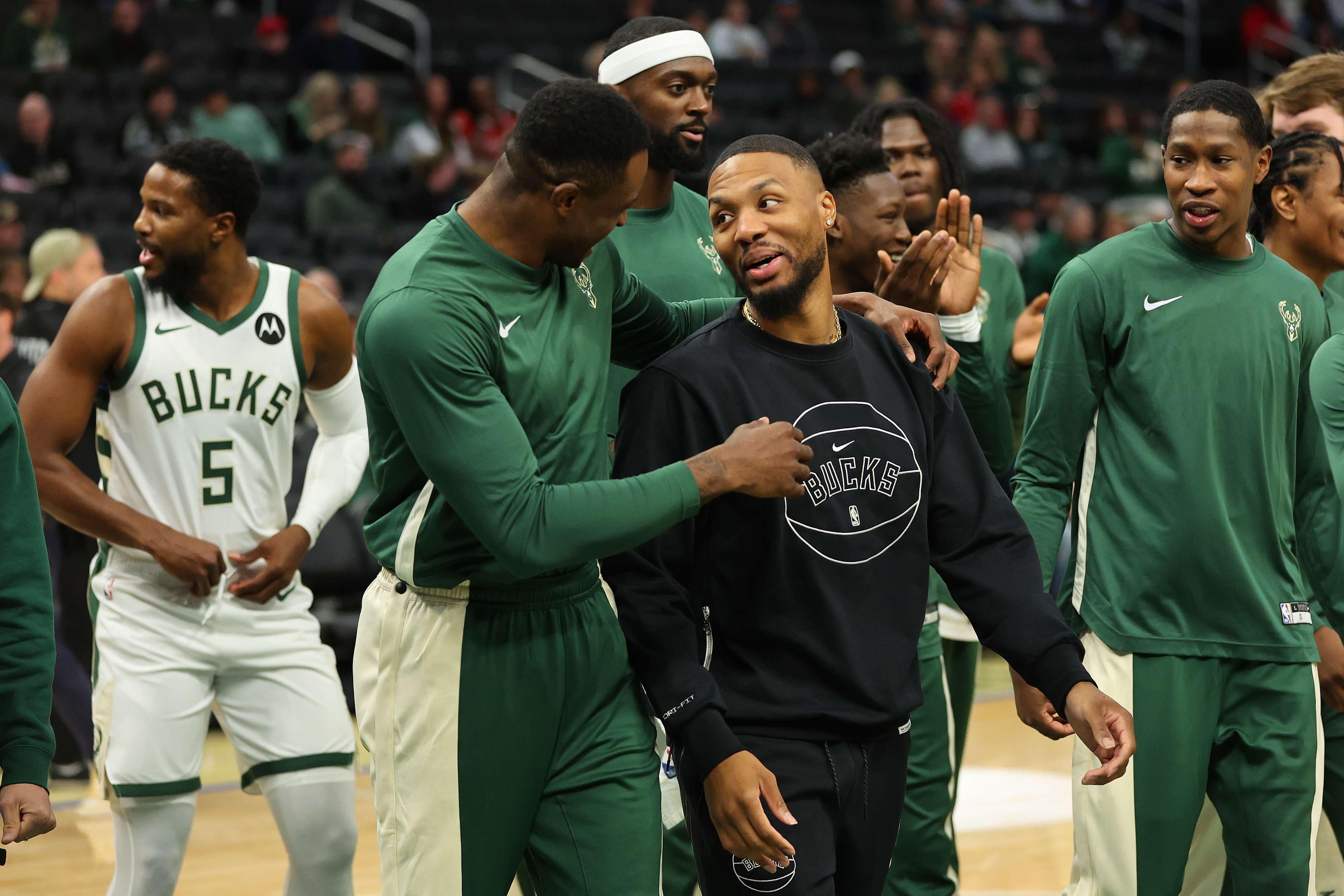 Milwaukee Bucks players sharing a light moment on the court pre-game