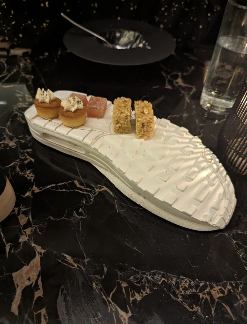 Assorted appetizers presented on a sneaker serving plate on a marble table