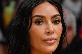 Kim Kardashian wearing a strapless black top, with straight long hair, looking forward