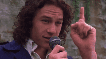 Heath Ledger sostiene un micrófono y gesticula con el dedo índice levantado en la película &#x27;10 Things I Hate About You&#x27;