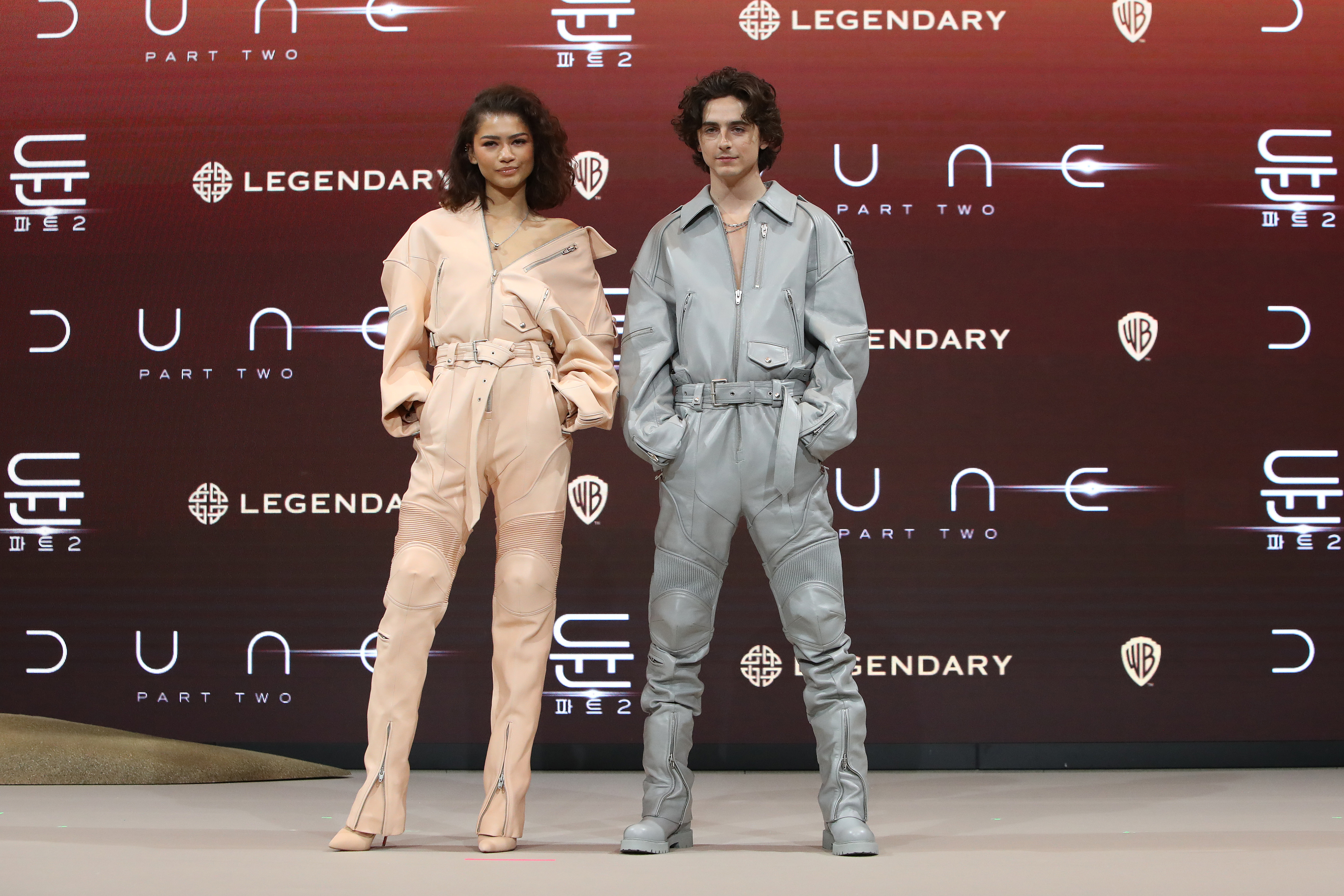 Zendaya and Timothée in stylish outfits pose at a Dune: Part Two event
