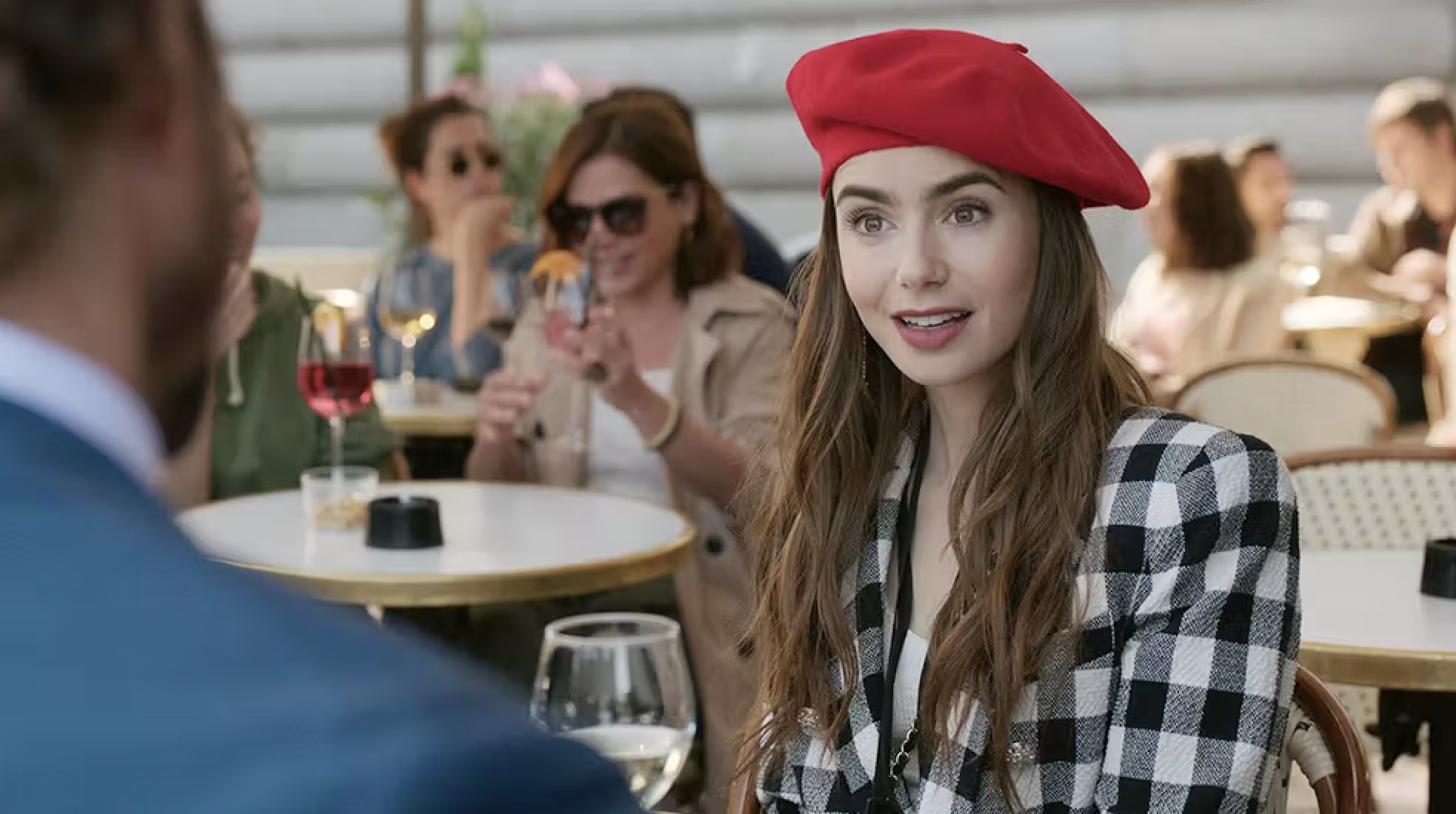 Woman in a checkered jacket and red beret from Emily in Paris