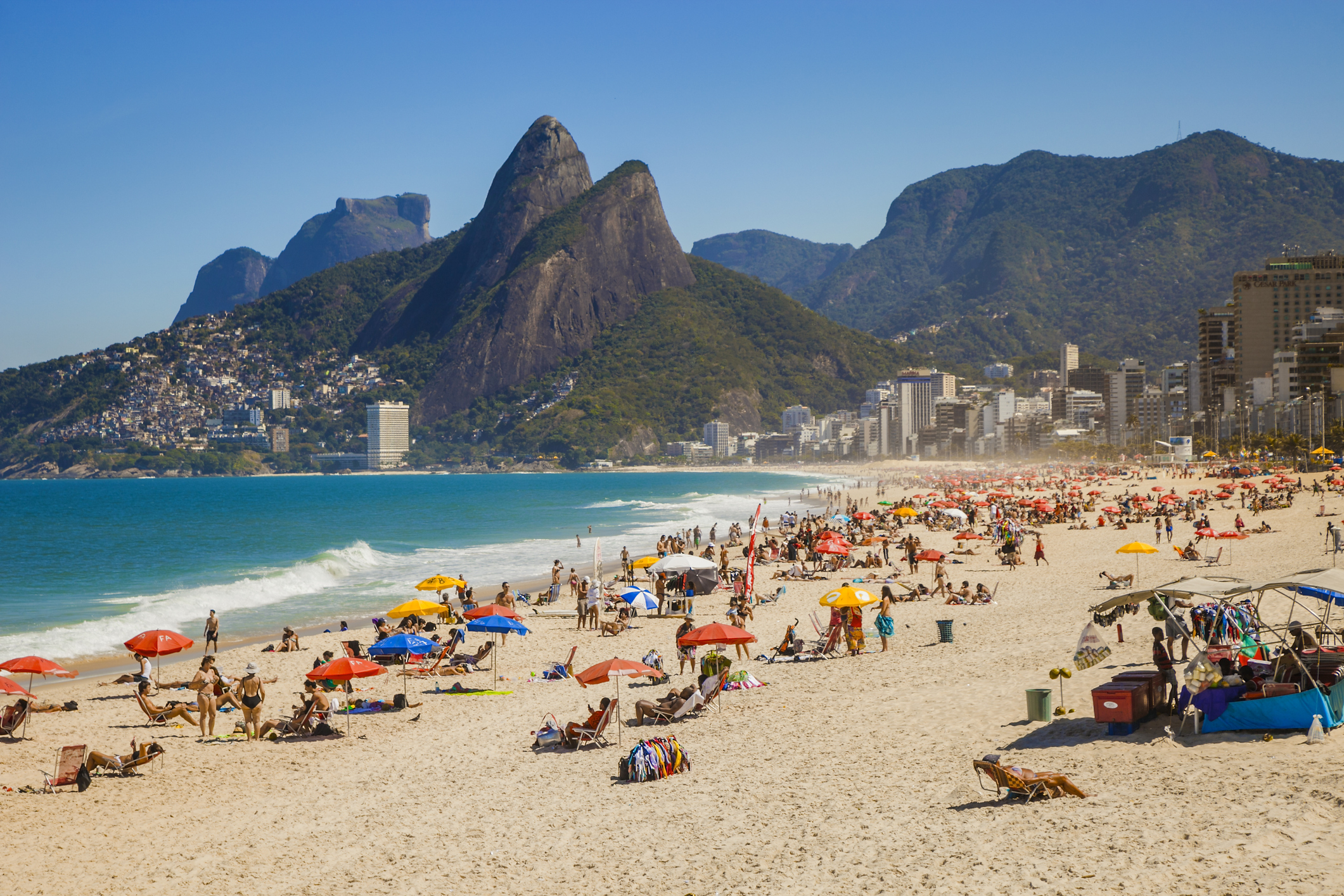 Crowded beach with people sunbathing and umbrellas in Rio