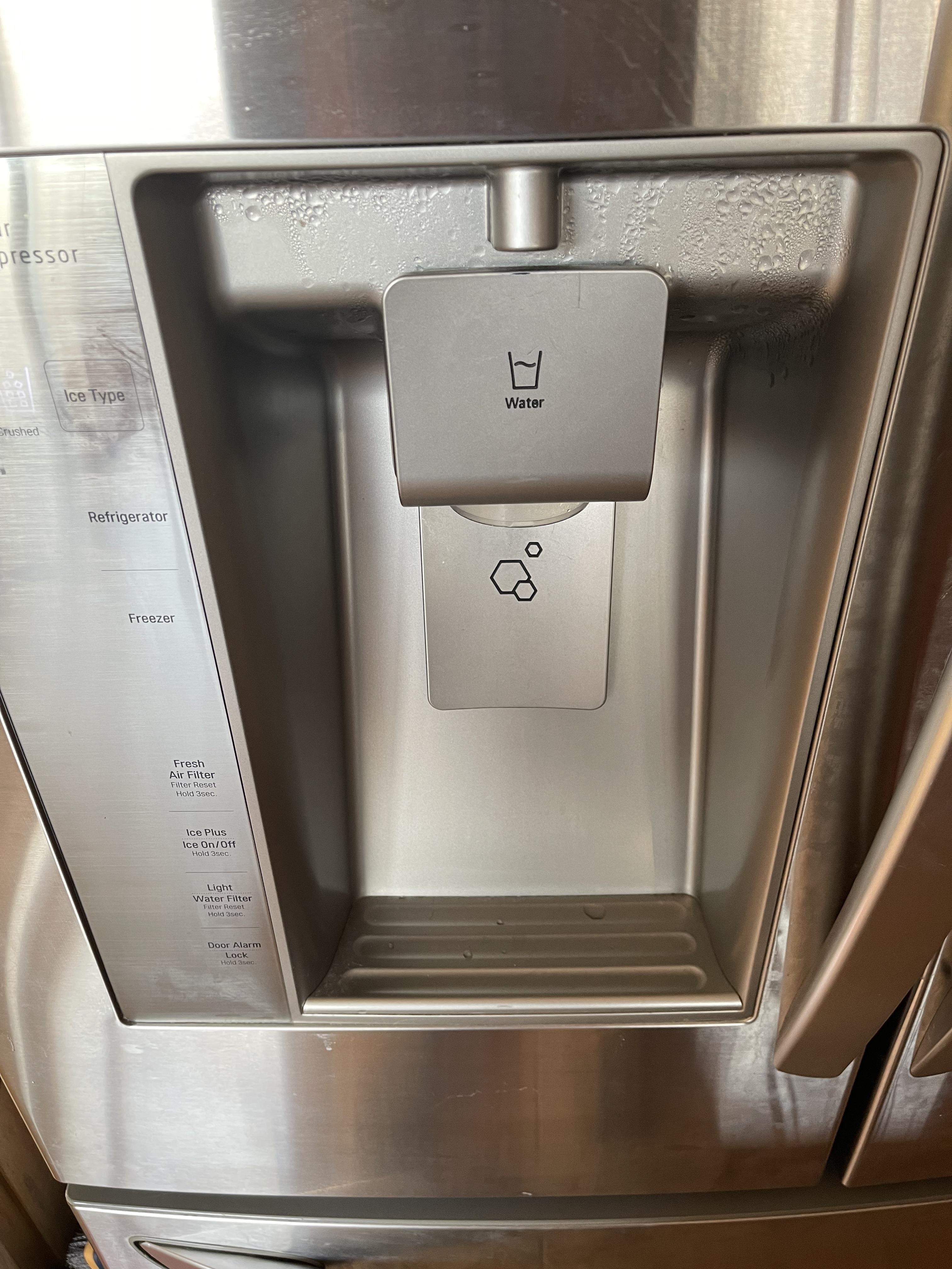 A refrigerator water and ice dispenser with clearly marked buttons