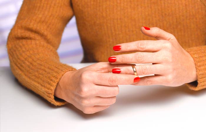 Person removing wedding ring from finger