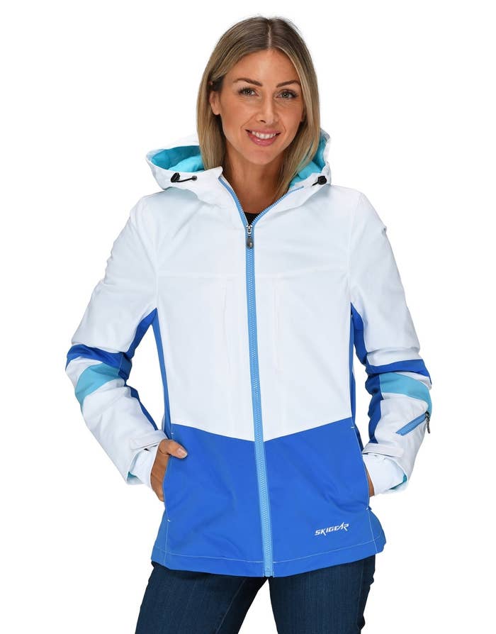 model in a white and blue jacket with a hood, standing against a plain background