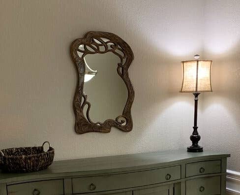 The mirror on the wall over a dresser