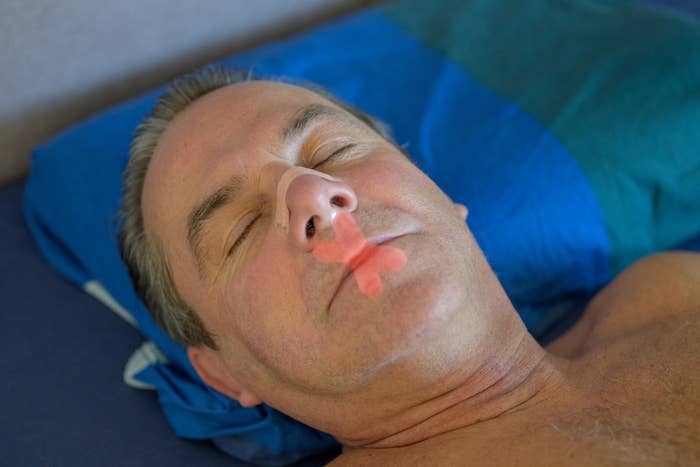 Man sleeping with tape over his lips
