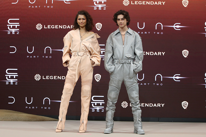 Zendaya and Timothee Chalamet in matching outfits posing at a "DUNE, PART TWO" press conference