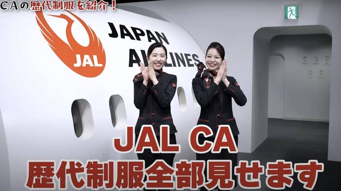 日本航空の制服を着た2人の女性客室乗務員が笑顔で手を挙げています。