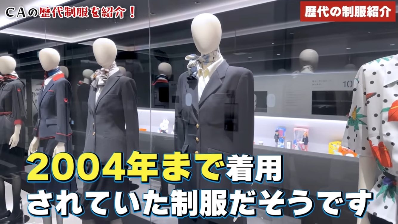 マネキンが並ぶショーウィンドウ、中央に文字「2004年まで着用されていた制服ビジュアル」