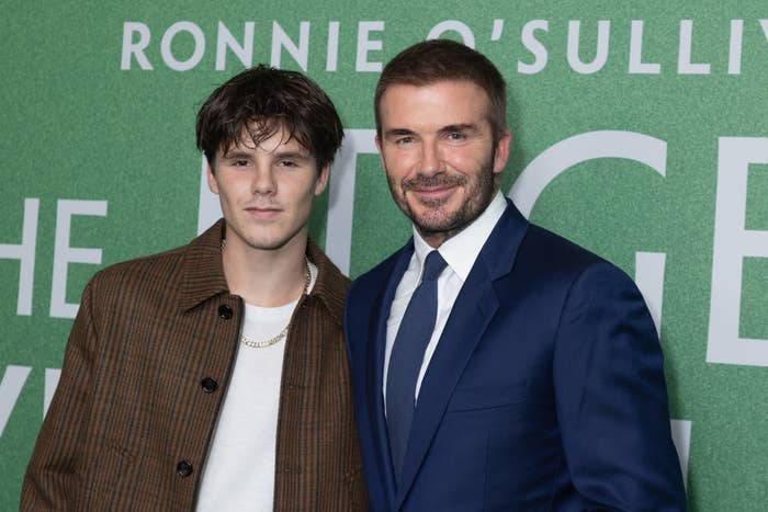 Two people posing for a photo, one in a patterned blazer and the other in a blue suit