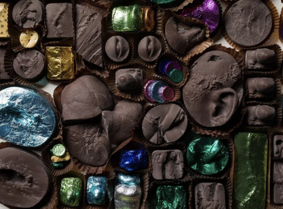 An assortment of chocolates in various shapes, some wrapped in metallic foil