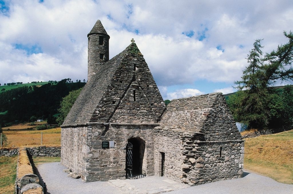 Historic stone structure with distinctive conical roof set in a rural landscape