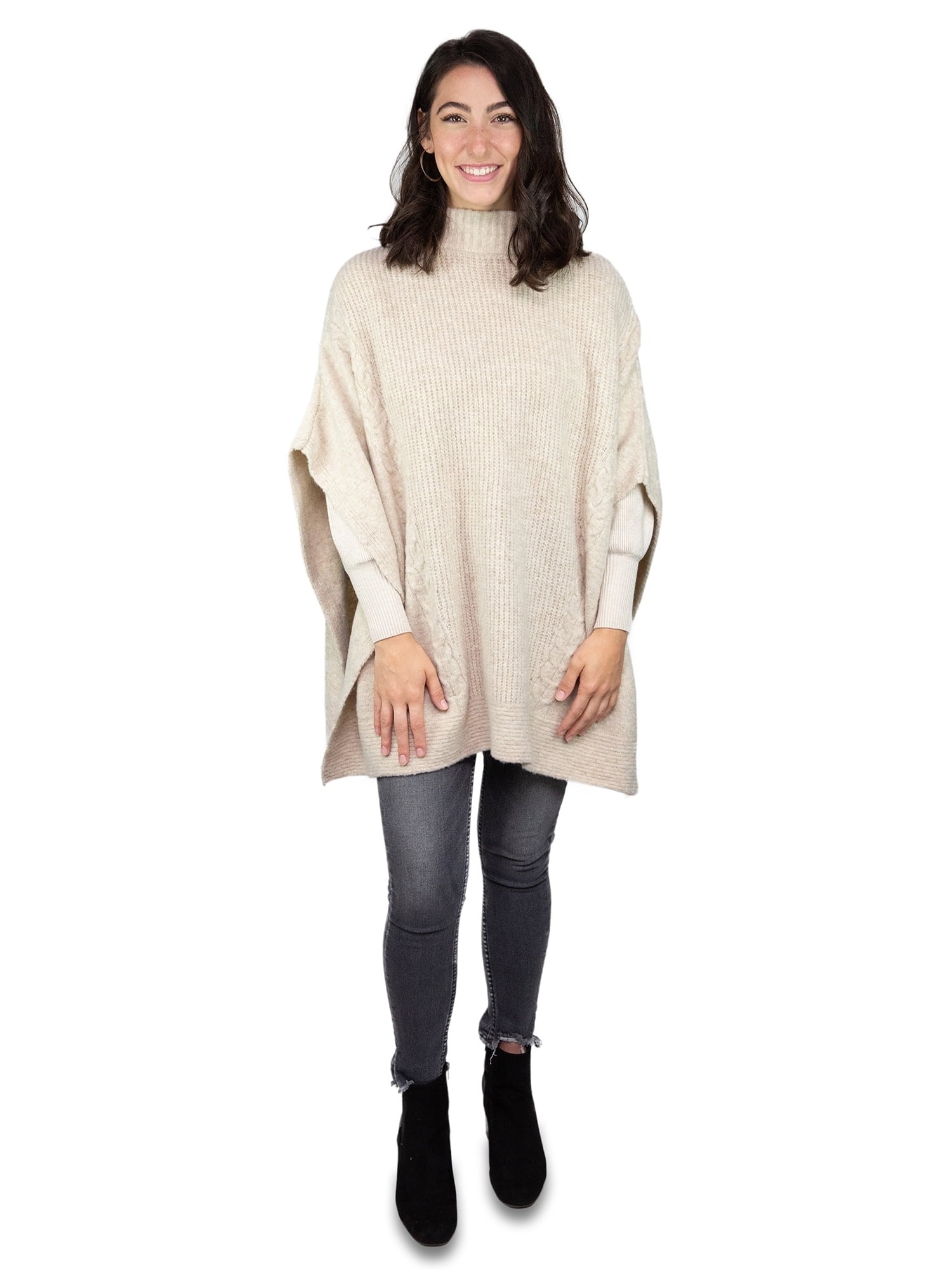 model in oversized cream colored, knit poncho, skinny jeans, and ankle boots