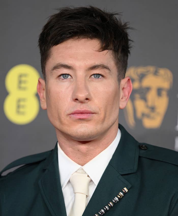 Barry Keoghan in military-style outfit at an event with award logos in background