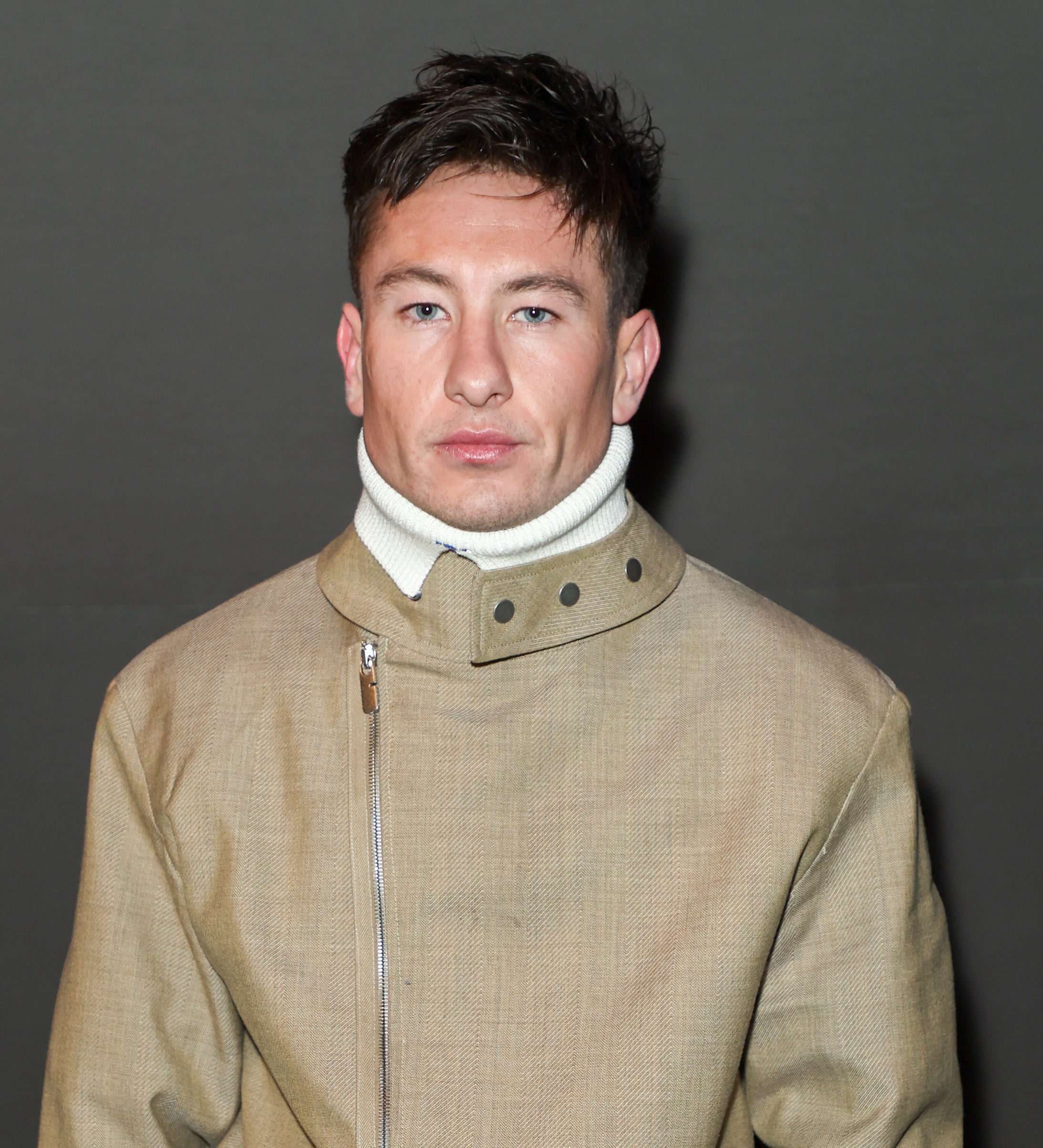 Barry Keoghan in a beige turtleneck and matching jacket with zipper and buckle detail