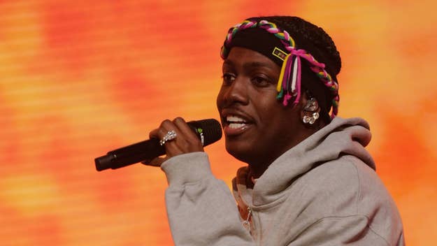 Lil Yachty on stage with a microphone, wearing a headband and earpiece