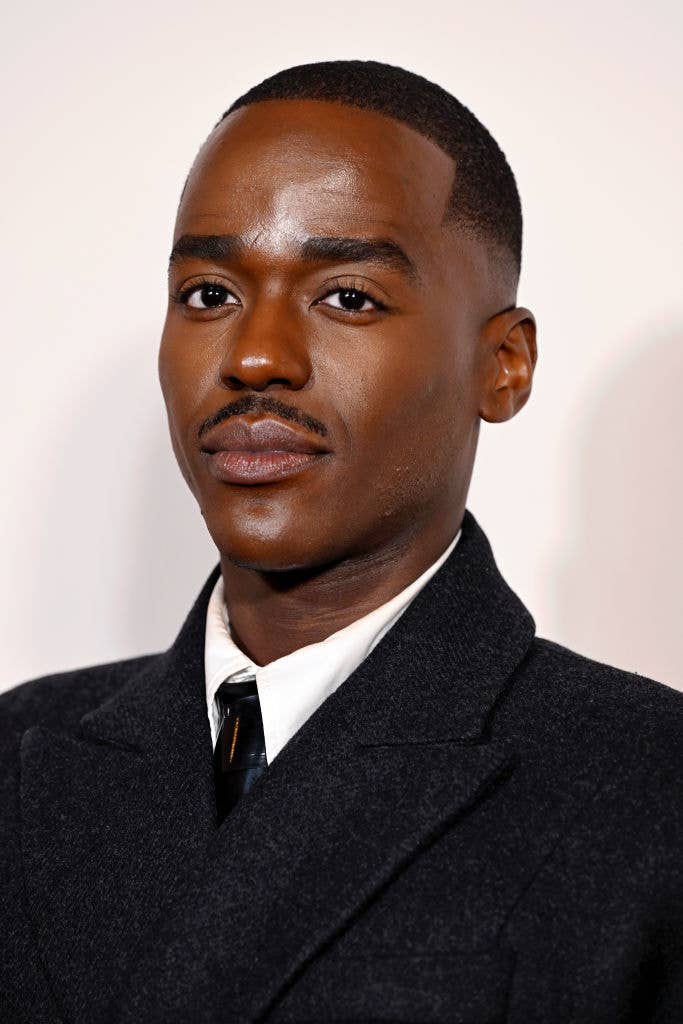 Ncuti Gatwa in a formal dark suit and tie, looking at the camera