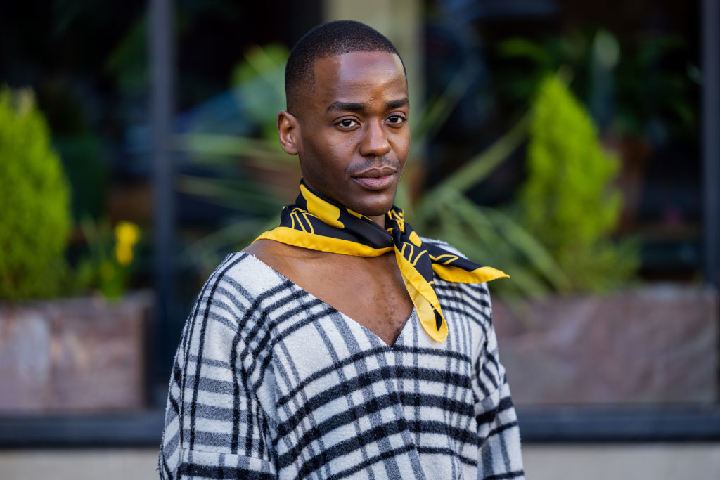 Person in a striped sweater and yellow scarf posing for the camera