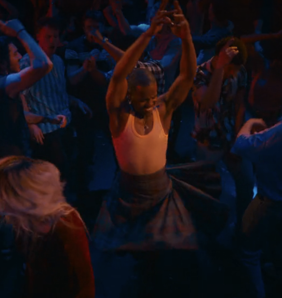 the Doctor wearing a kilt and dancing energetically in a crowded party scene