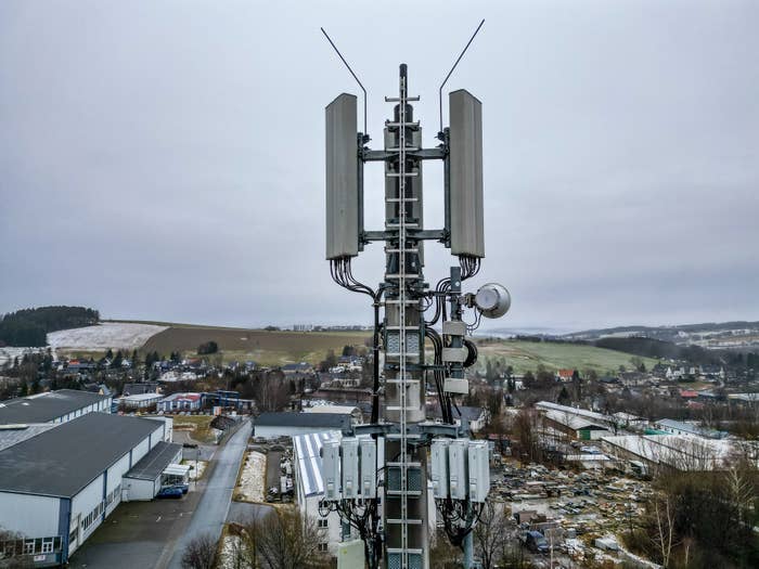 Cellular tower with various antennas overlooking a rural landscape