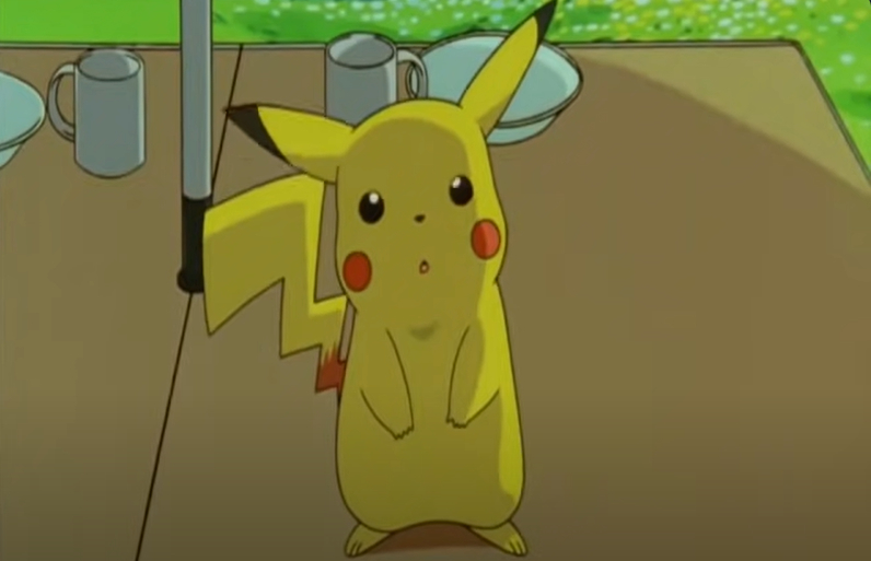 Pikachu from Pokémon sits at a table, looking up