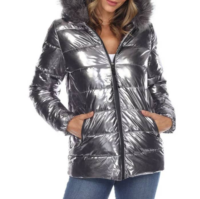 Woman in metallic puffer jacket with fur-lined hood, hands in pockets, for a shopping feature