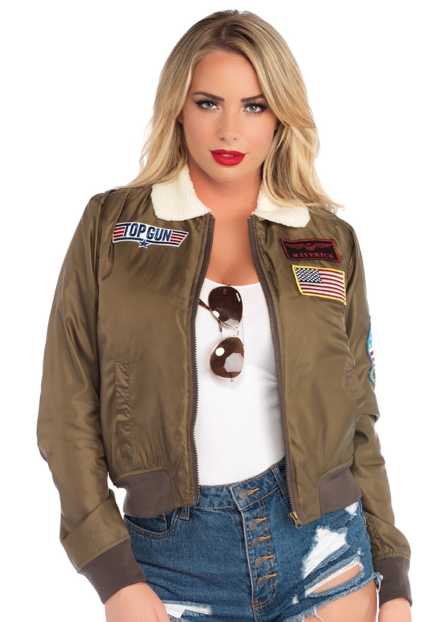 a model in a Top Gun bomber jacket with patches, white top, and denim shorts