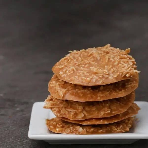 A stack of coconut toffee cookies on a white plate