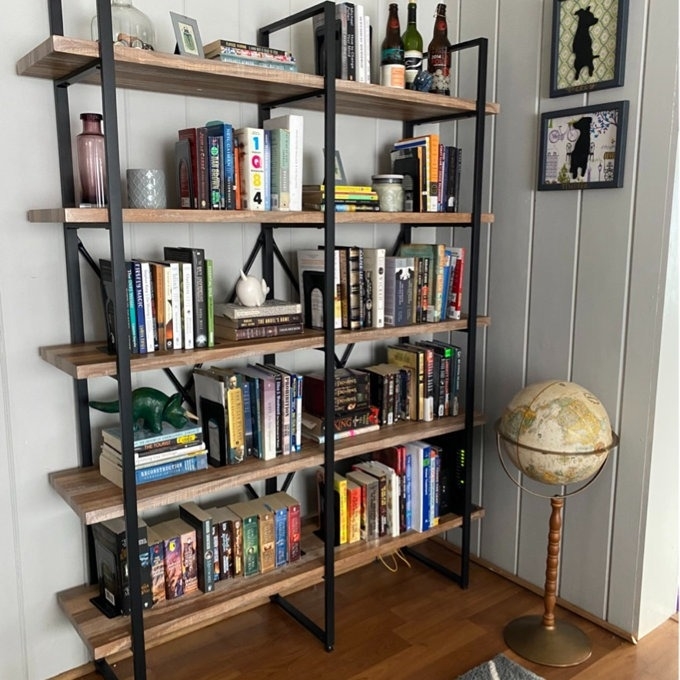 A bookshelf with a mix of books and decorative items, next to a standing globe