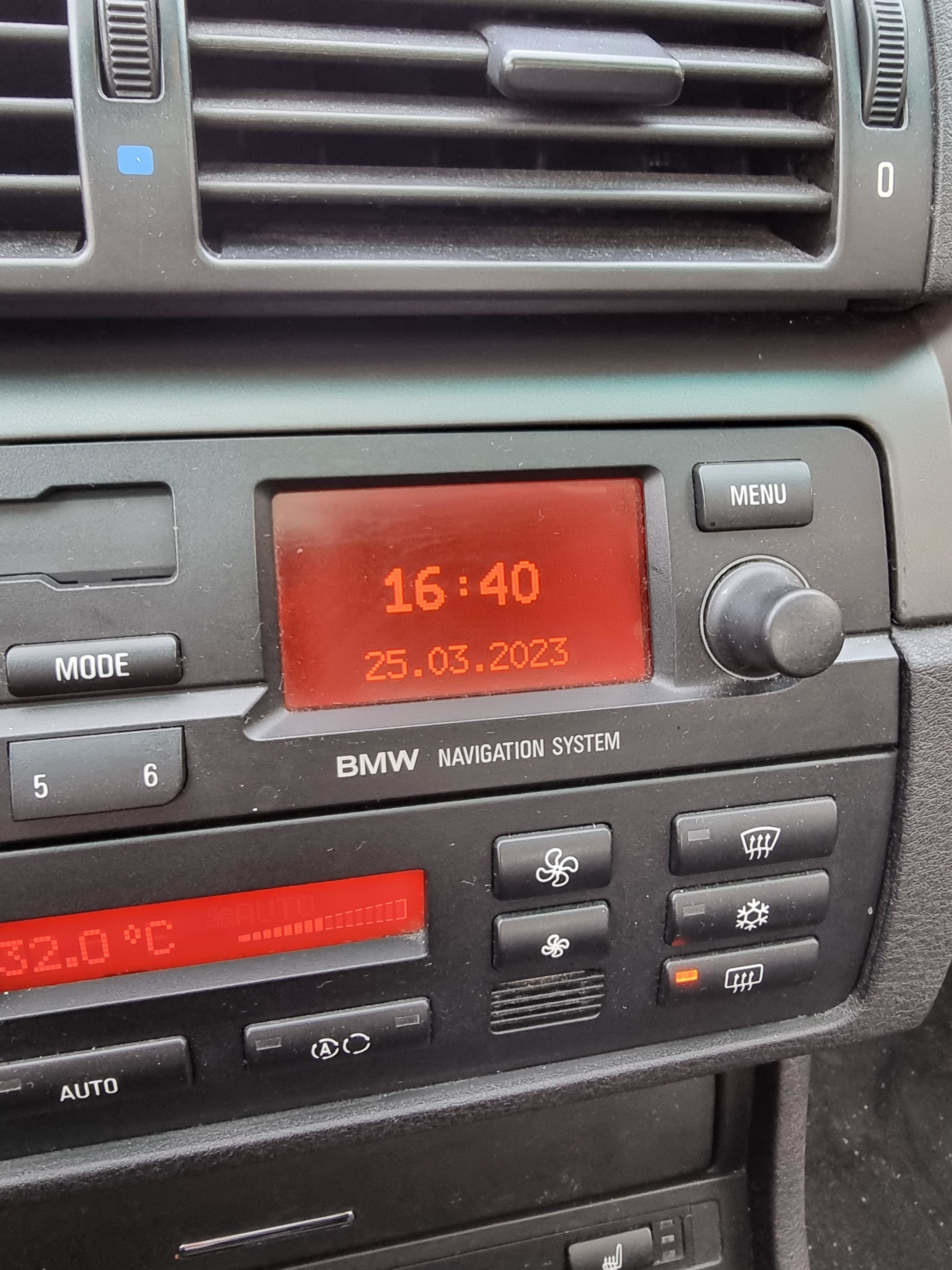 Car dashboard showing BMW Navigation System with time and date displayed