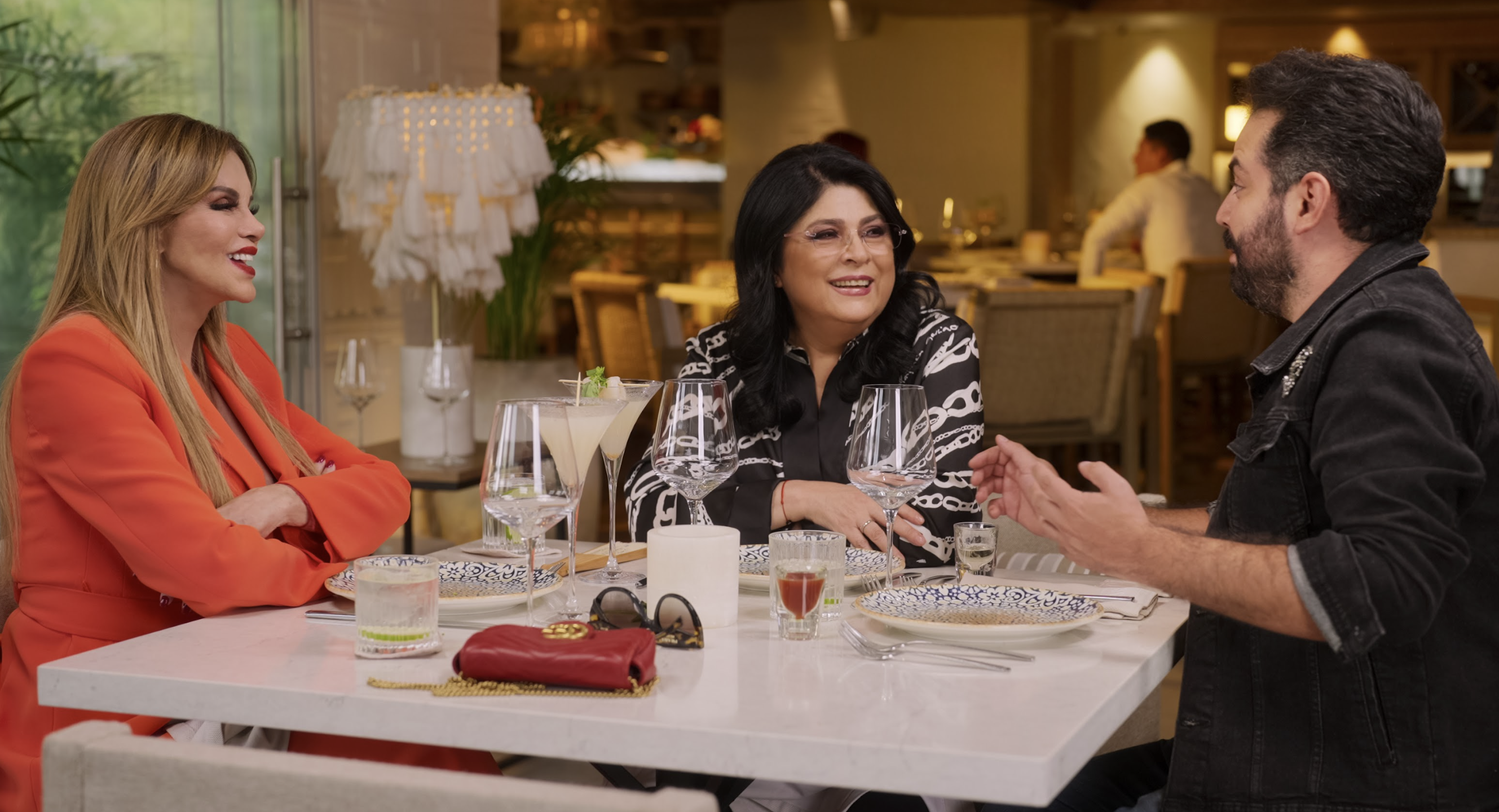 Tres personas conversando animadamente en un restaurante elegante