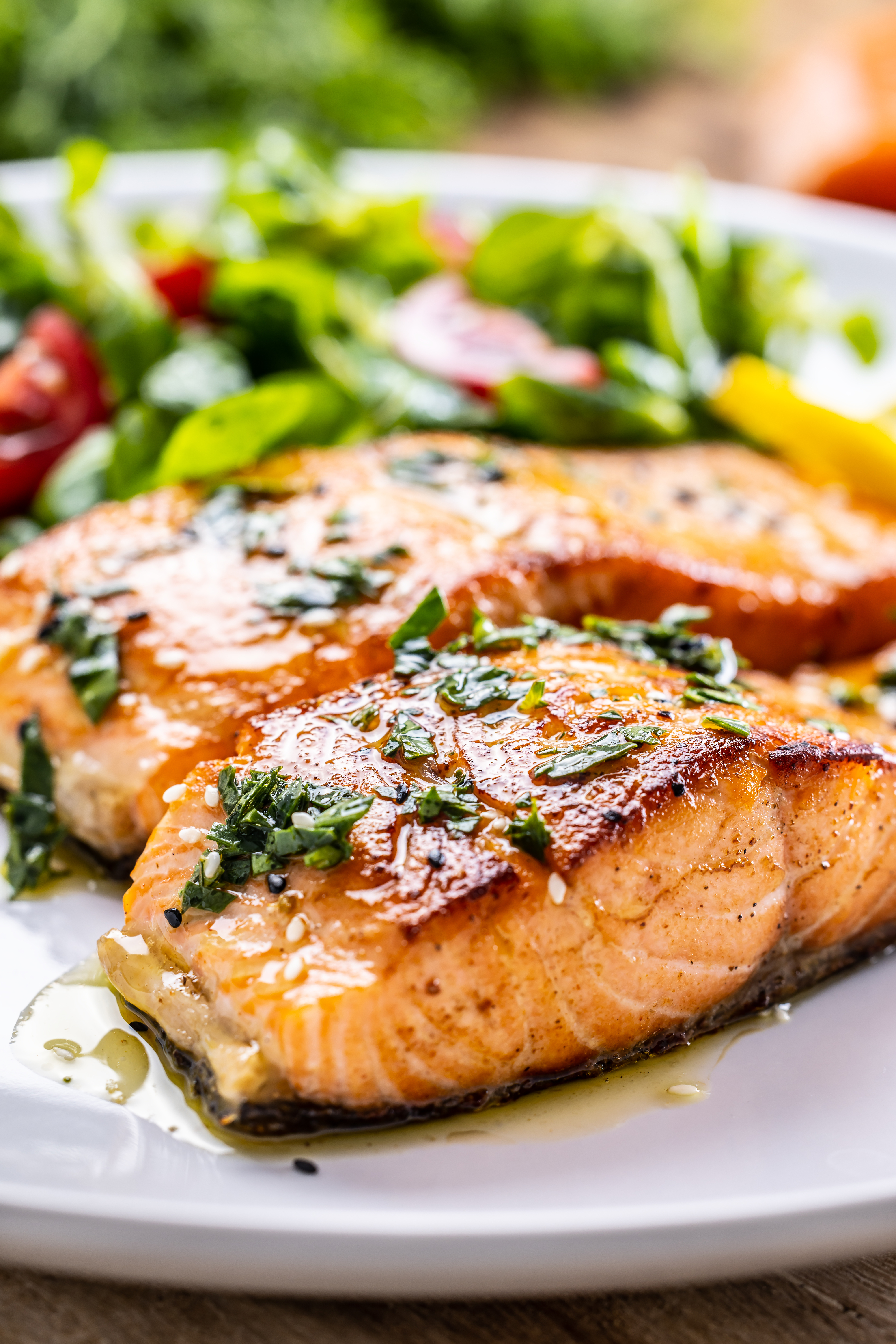Grilled salmon fillets on a plate with a side salad