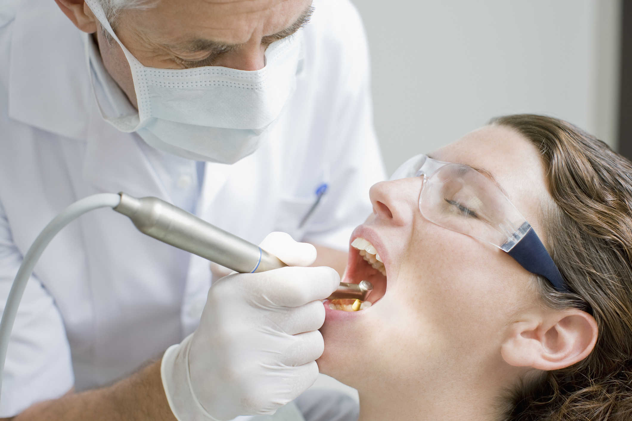 Dentist performing a dental procedure on a female patient in a clinic