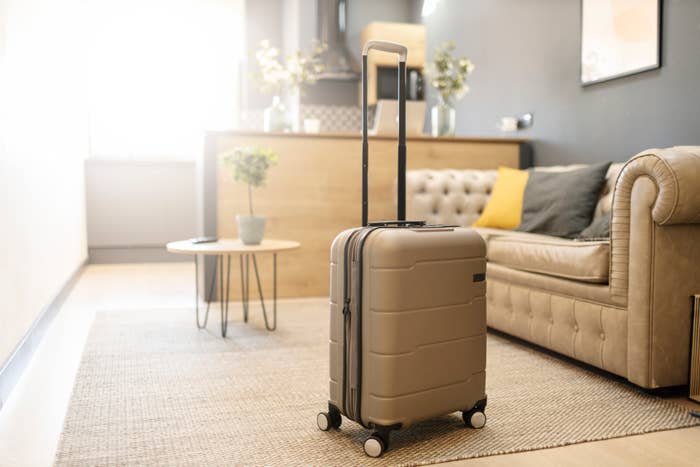 Closed suitcase standing in a tidy living room, suggesting travel or arrival