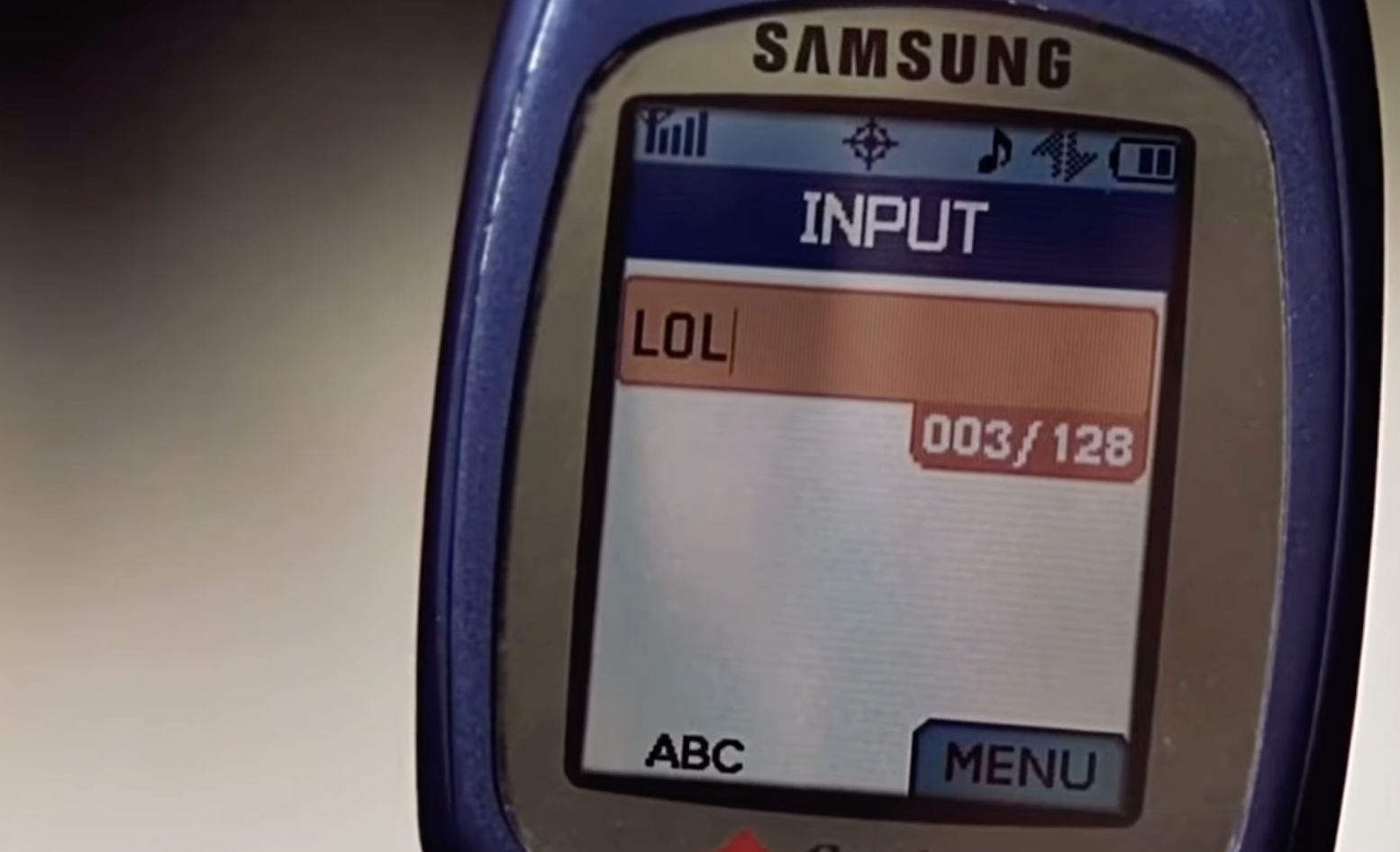 Old Samsung flip phone screen displaying text message inbox with &quot;LOL&quot; as the content of a message