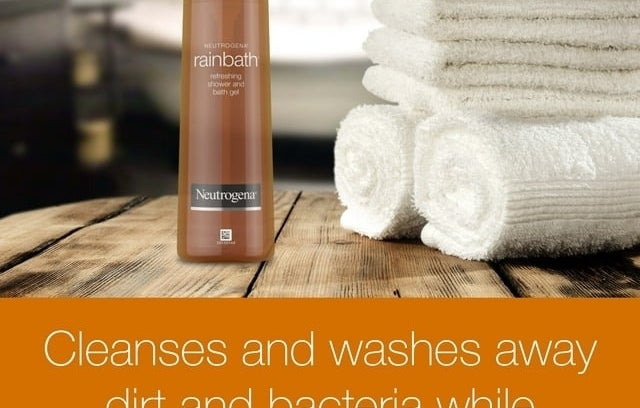 Neutrogena Rainbath shower gel on wooden surface with clean towels in background
